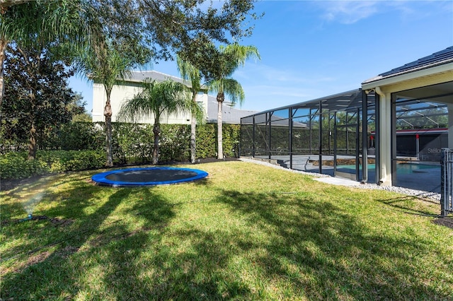 view of yard featuring a lanai and a trampoline