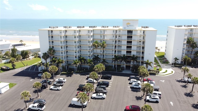 view of building exterior featuring a water view and a beach view