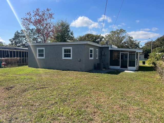 1315 Carlsbad Pl, Orlando, FL 32808 - back of house with a sunroom, central AC unit, and a lawn