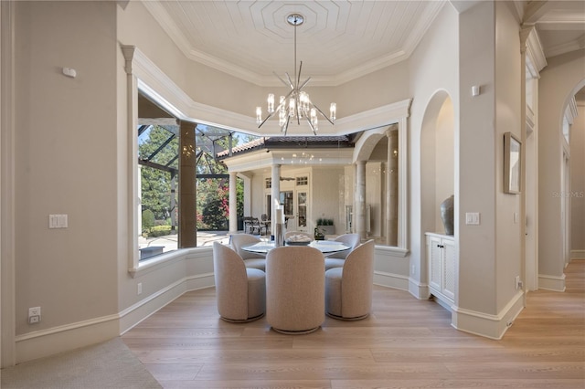 dining space with crown molding, a notable chandelier, and light hardwood / wood-style floors