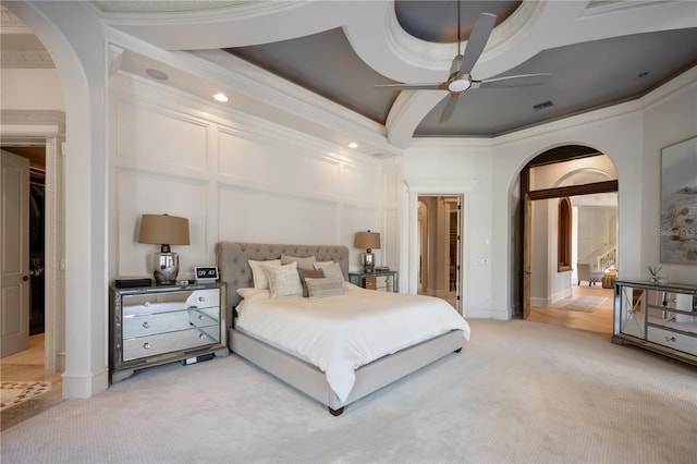 bedroom with light carpet, ornamental molding, and ceiling fan