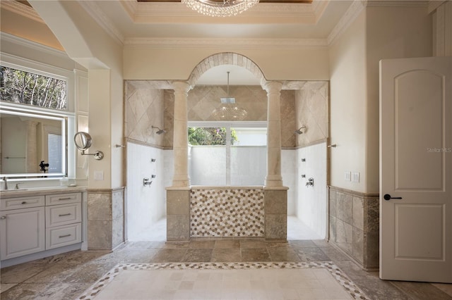 bathroom featuring crown molding, vanity, tile walls, and a tile shower