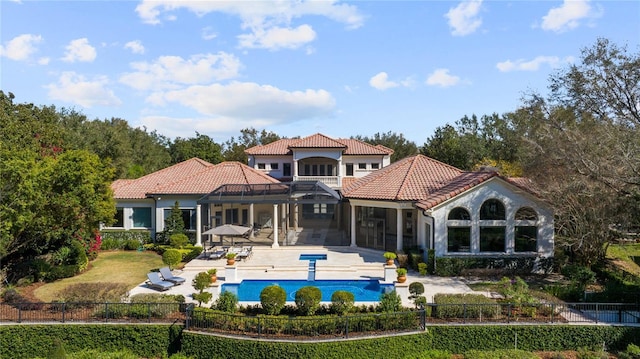 rear view of property with a lanai, a fenced in pool, and a patio area