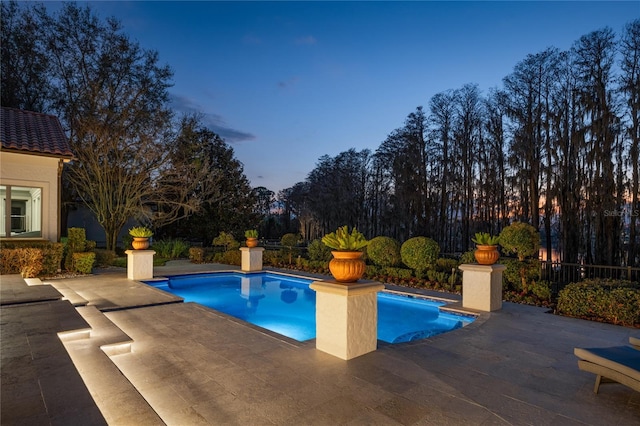 pool at dusk with a patio