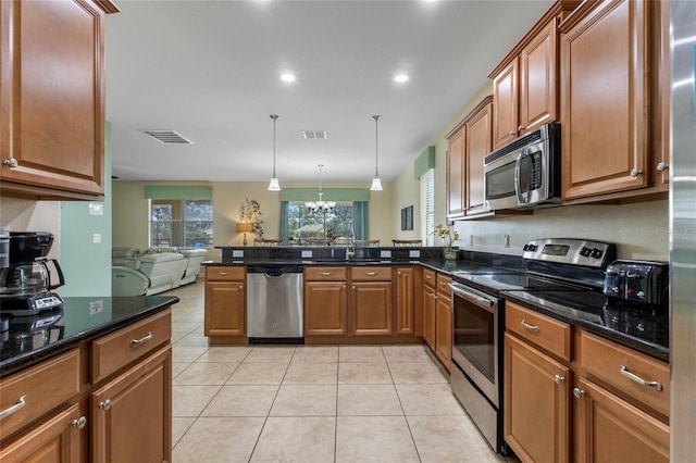1494 Moon Valley Dr, Davenport, FL 33896 - kitchen with appliances with stainless steel finishes, a peninsula, open floor plan, light tile patterned flooring, and brown cabinetry