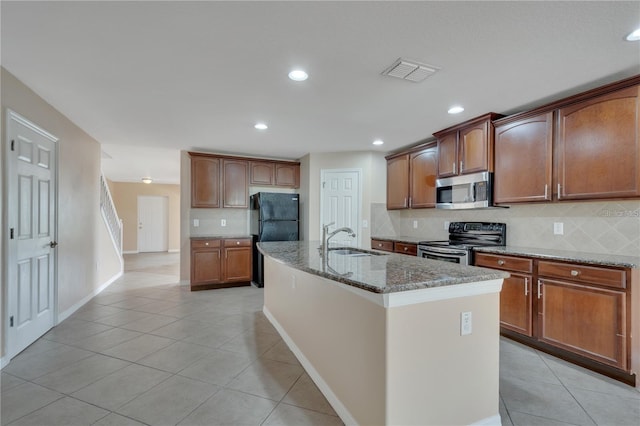 1515 Angler Ave, Kissimmee, FL 34746 - kitchen featuring sink, a kitchen island with sink, stainless steel appliances, tasteful backsplash, and light stone countertops