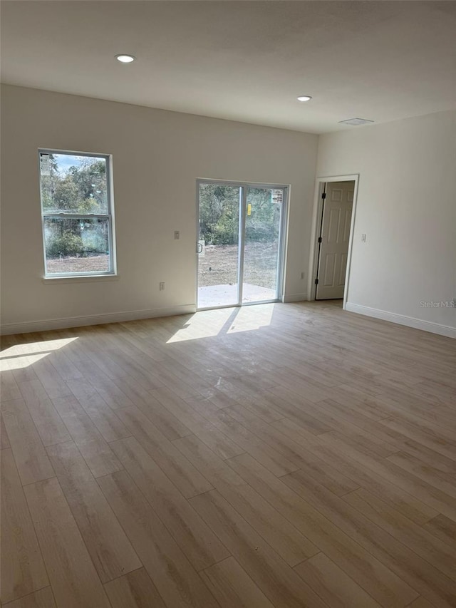 empty room featuring light wood-type flooring and a wealth of natural light