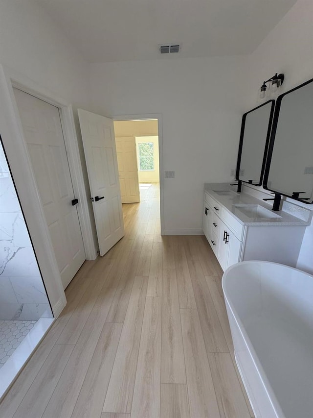 bathroom with vanity, plus walk in shower, and hardwood / wood-style floors