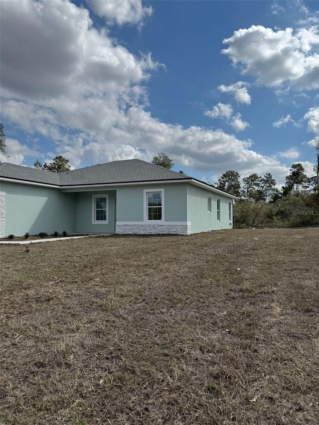 rear view of property featuring a yard