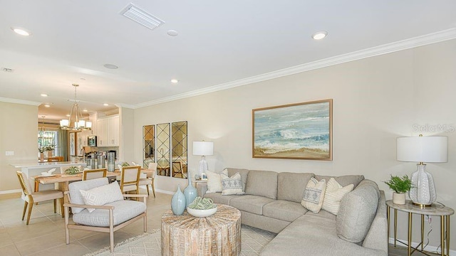 living room featuring an inviting chandelier, ornamental molding, and light tile patterned floors