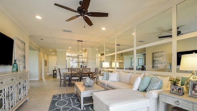 tiled living room with crown molding and ceiling fan with notable chandelier