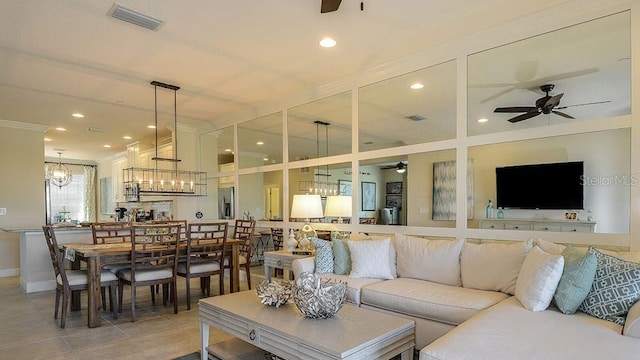 tiled living room featuring ceiling fan with notable chandelier