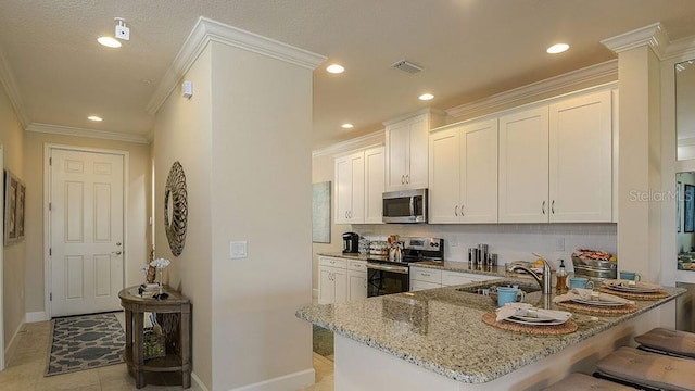 kitchen featuring white cabinetry, light stone countertops, a kitchen breakfast bar, and appliances with stainless steel finishes