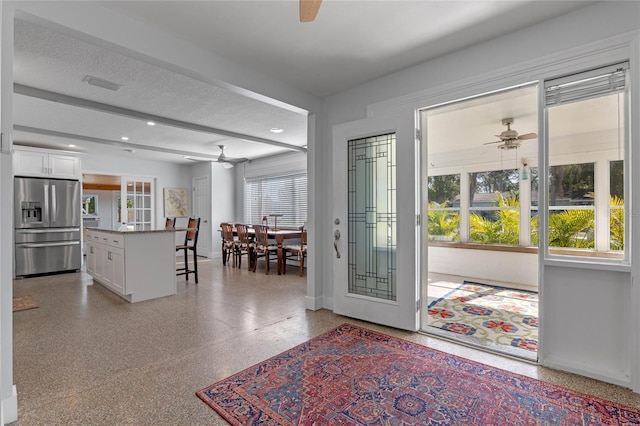 entryway with ceiling fan and a textured ceiling