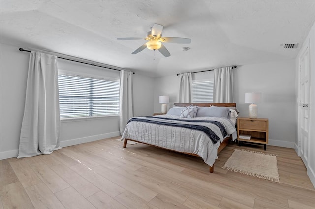 bedroom with ceiling fan, a textured ceiling, and light hardwood / wood-style floors