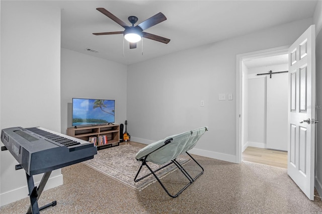 interior space with a barn door and ceiling fan