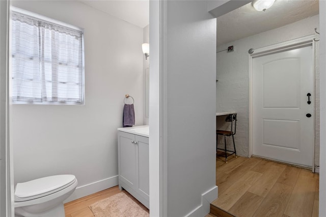 bathroom with vanity, hardwood / wood-style floors, and toilet