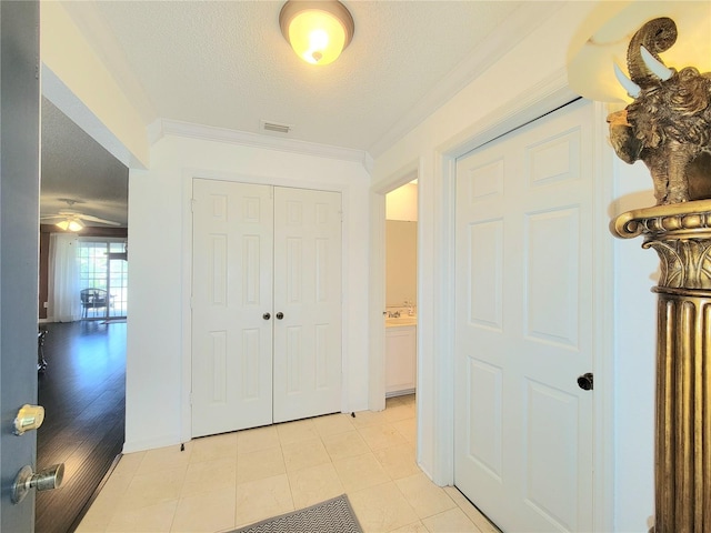 hallway with crown molding and a textured ceiling