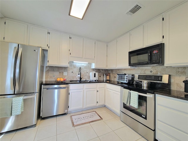 kitchen featuring sink, backsplash, white cabinets, and appliances with stainless steel finishes