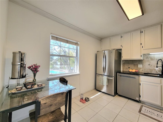 kitchen with stainless steel appliances, ornamental molding, sink, and white cabinets