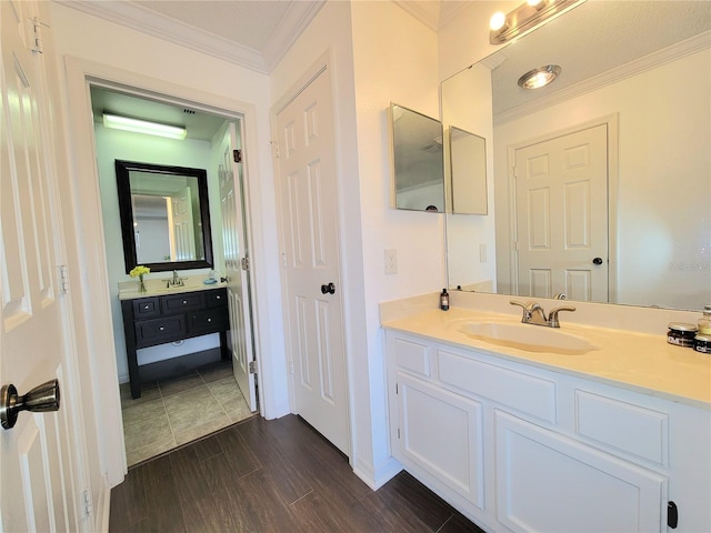 bathroom with crown molding, wood-type flooring, and vanity