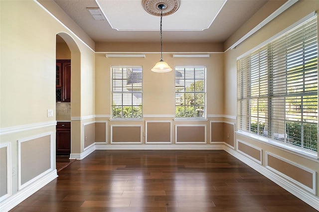 unfurnished dining area featuring dark wood-type flooring and a healthy amount of sunlight