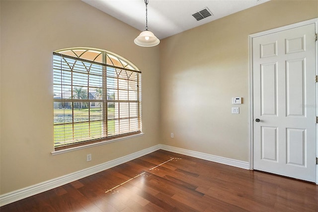 spare room featuring vaulted ceiling and dark hardwood / wood-style flooring