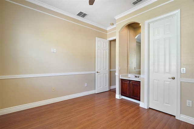 unfurnished bedroom with crown molding, ceiling fan, wood-type flooring, and sink