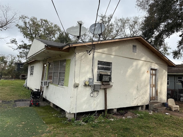 view of property exterior with cooling unit and a lawn