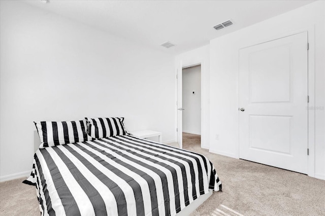 bedroom featuring baseboards, visible vents, and light colored carpet