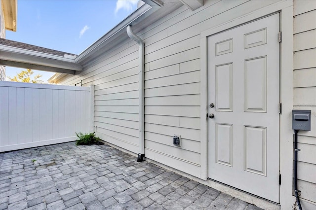 doorway to property featuring fence and a patio