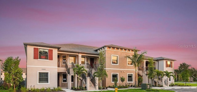 view of front of home with cooling unit and a lawn