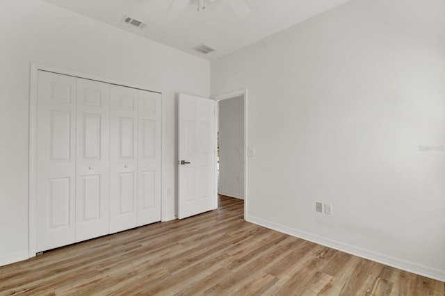 unfurnished bedroom with ceiling fan, a closet, and light wood-type flooring