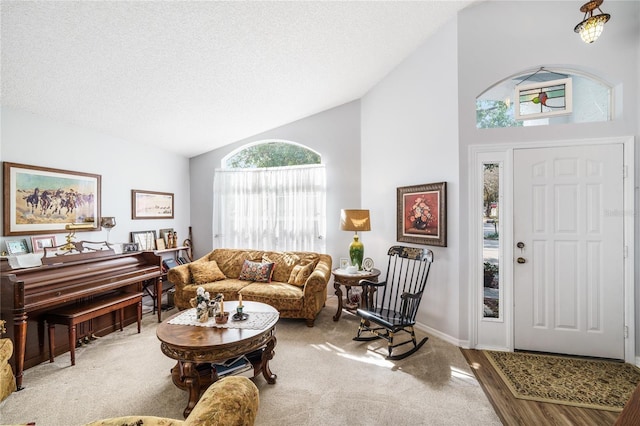 foyer with high vaulted ceiling, baseboards, and a textured ceiling