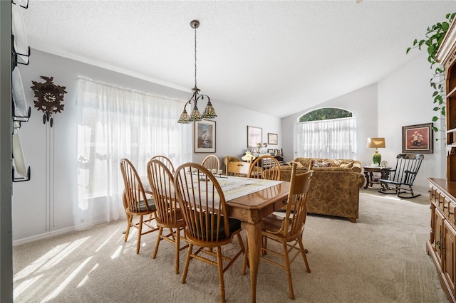 dining space featuring light colored carpet, vaulted ceiling, and a textured ceiling