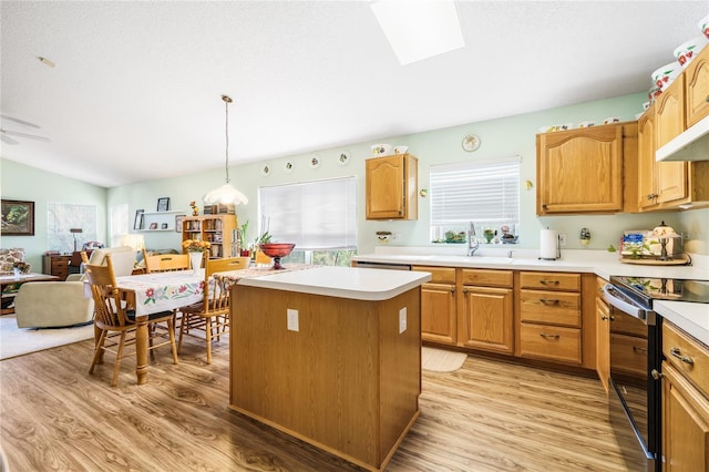 kitchen featuring a sink, a kitchen island, light countertops, electric range oven, and decorative light fixtures