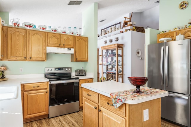 kitchen with stainless steel appliances, under cabinet range hood, light countertops, and a center island