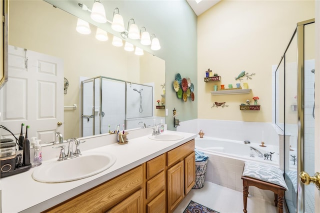 full bath with a bath, a stall shower, double vanity, and a sink