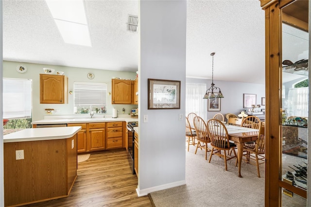 kitchen with hanging light fixtures, a skylight, visible vents, and light countertops