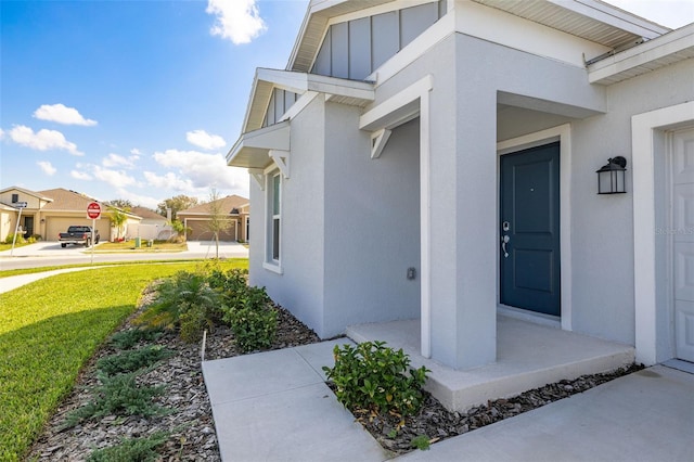 view of exterior entry featuring a lawn