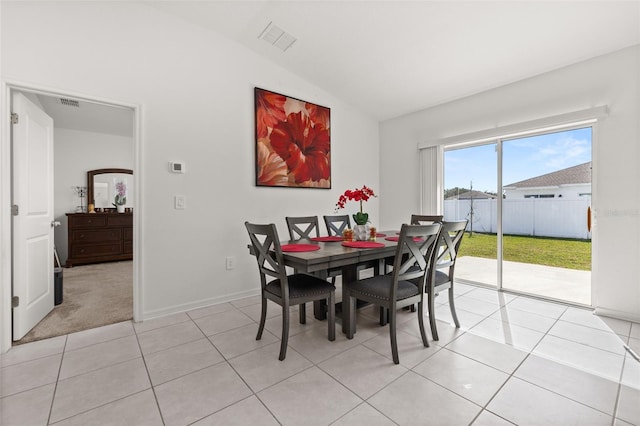 tiled dining room with vaulted ceiling