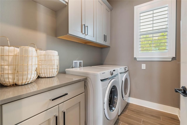 washroom with cabinets and washer and dryer