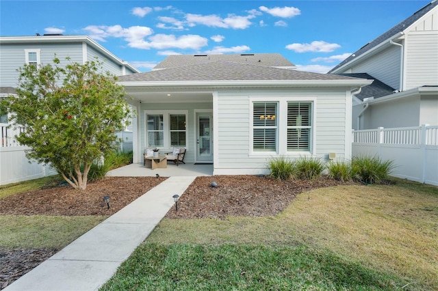 property entrance with a lawn and a patio area