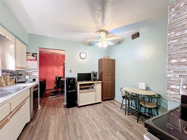 kitchen featuring tasteful backsplash, dishwasher, light hardwood / wood-style flooring, ceiling fan, and electric stove