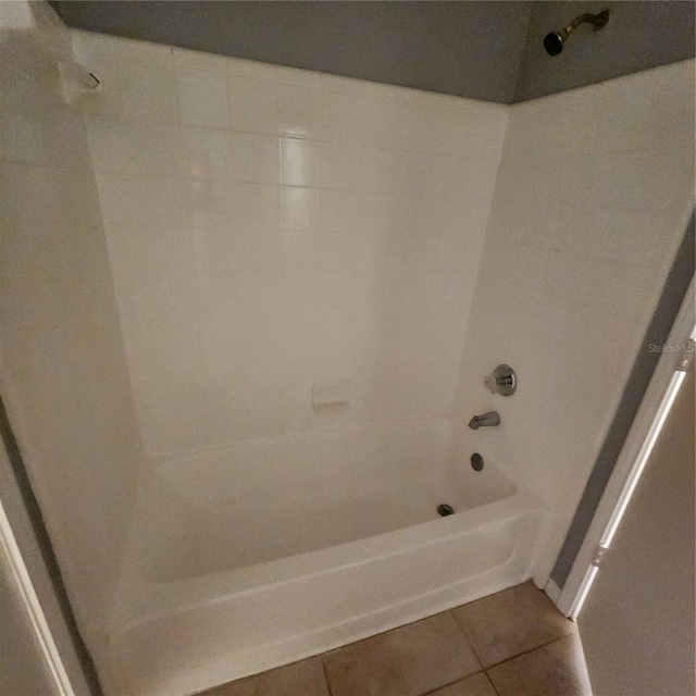 bathroom with tile patterned floors and shower / washtub combination