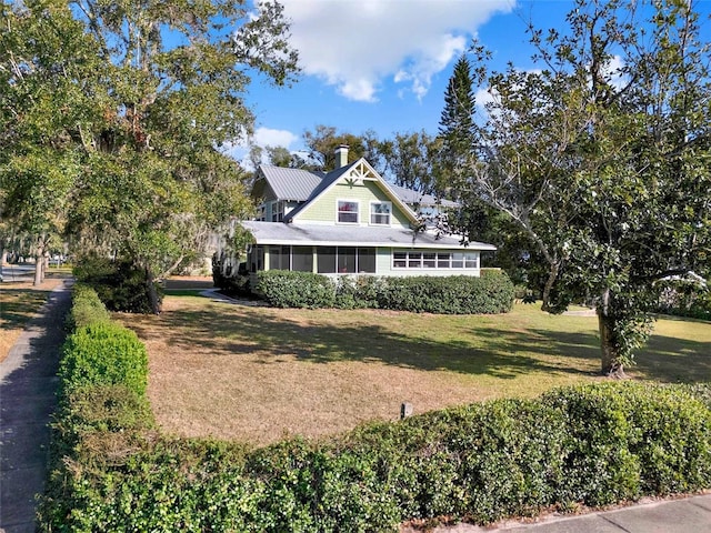 view of front of house with a front yard and a sunroom