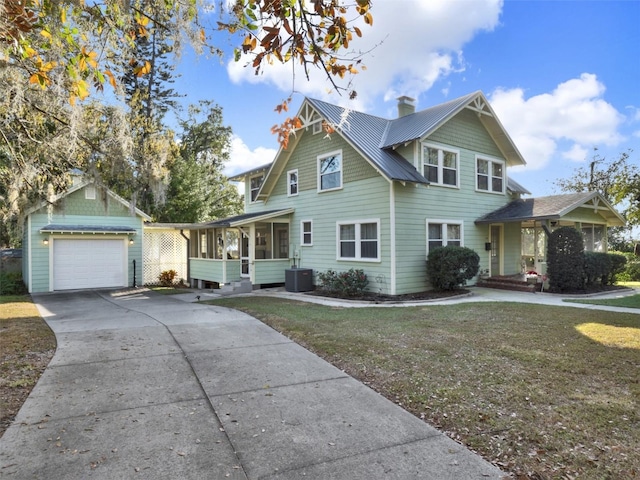 view of front facade featuring an outbuilding, a garage, central AC unit, and a front yard