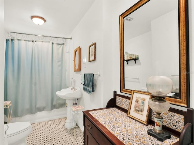 bathroom featuring shower / tub combo and toilet