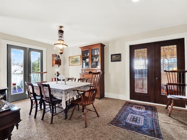 dining space featuring light carpet and french doors