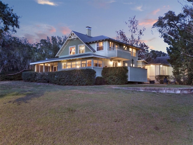 view of front of house with a lawn and a balcony